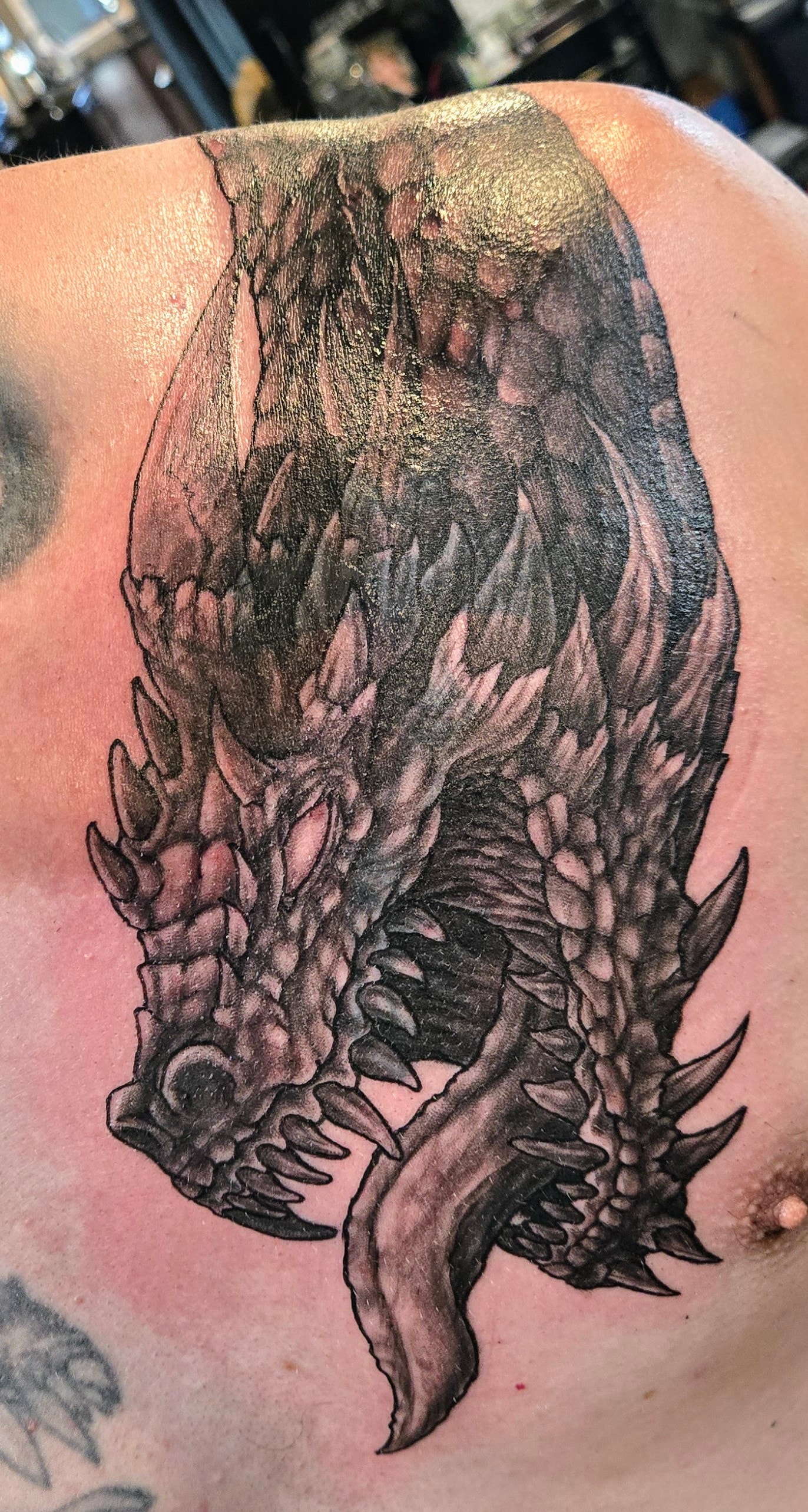 Shaded matching dragon cover-up tattoo on a shoulder